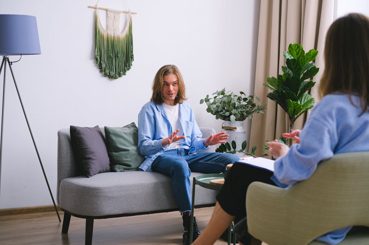 Man explaining himself during a therapy session while a counselor listens.